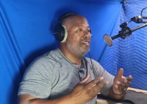 Cecil Archbold in a professional voice recording studio, focused and confident at the microphone